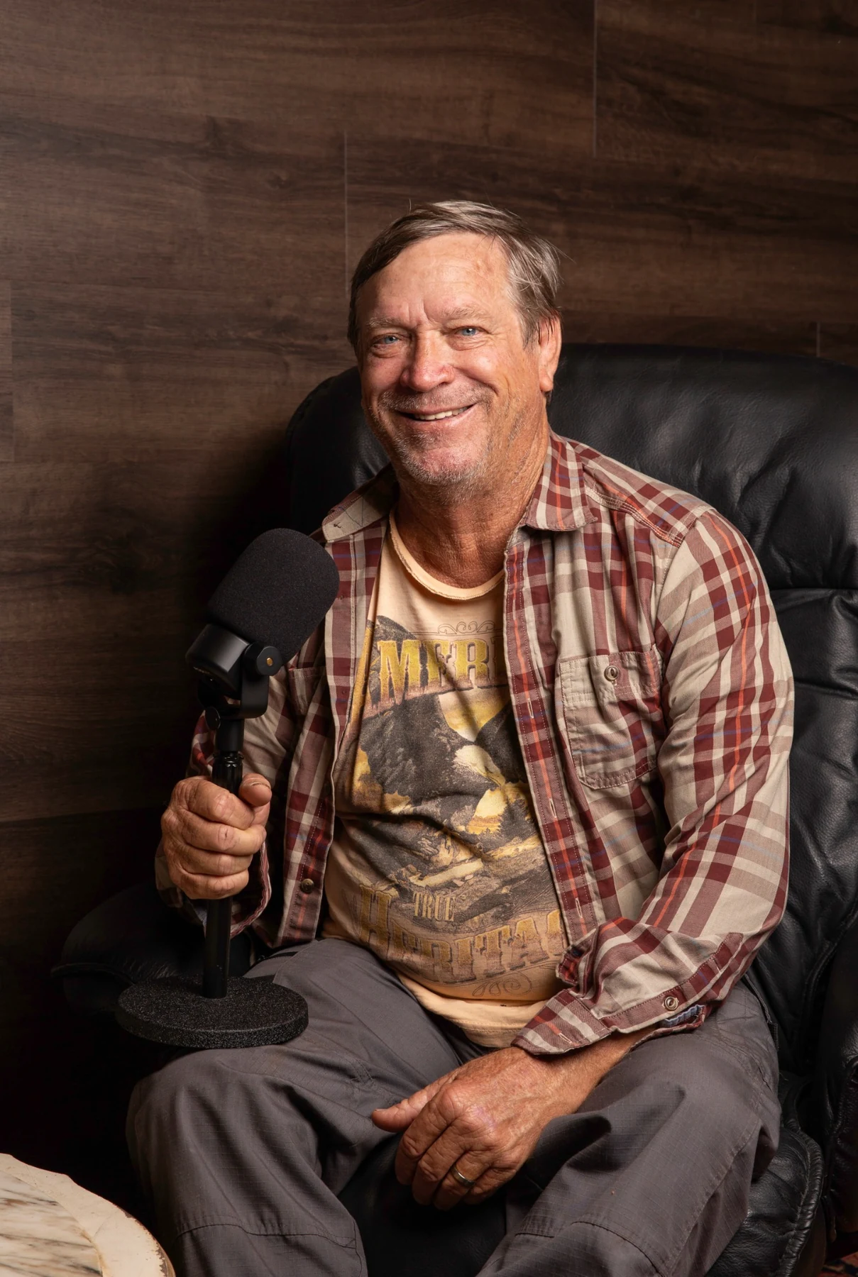 Host holding a podcast microphone